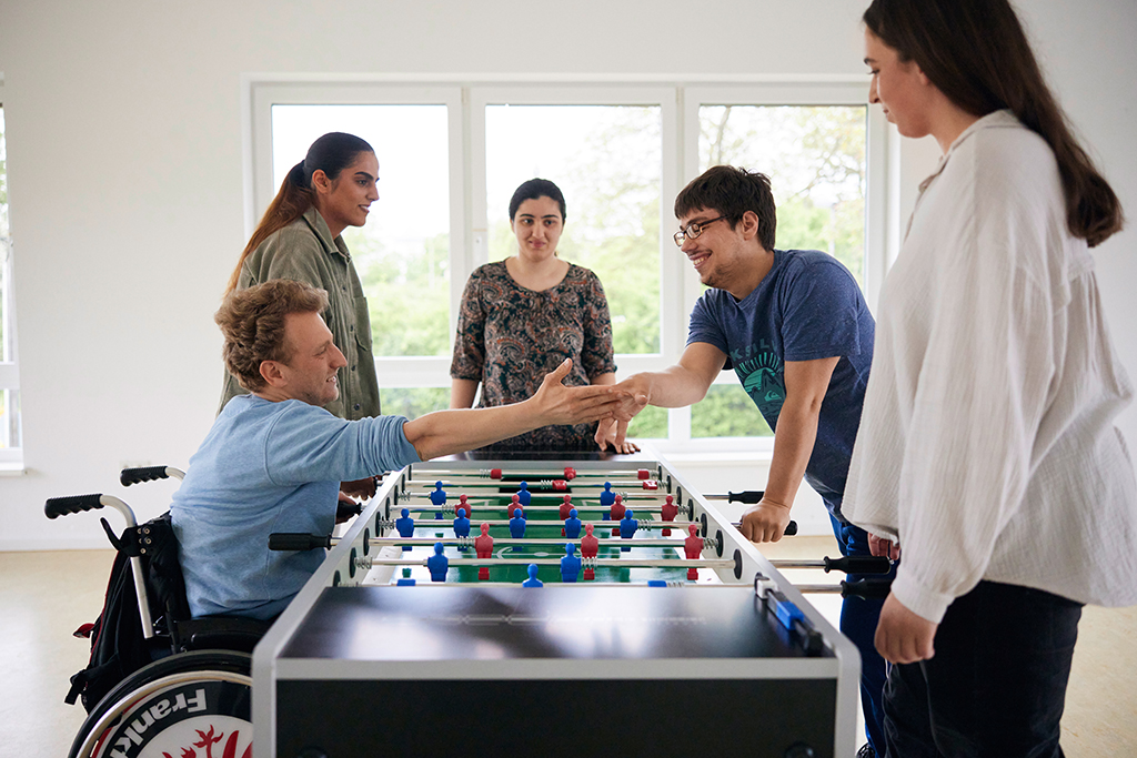 Ein Tischkicker-Match bei Freizeit und Reisen: Zwei der Spieler geben sich die Hand.