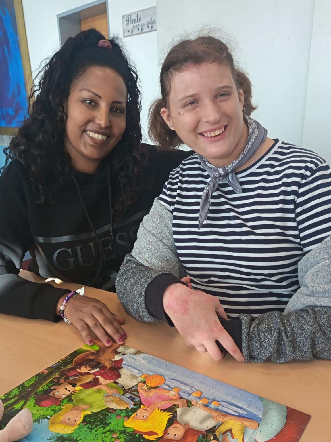 Eine Assistentin und eine Urlauberin haben Spaß beim gemeinsamen Puzzeln.