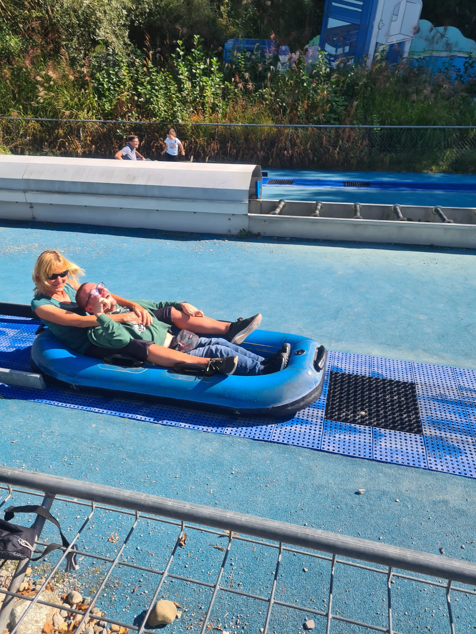 Assistenz und Urlauber haben gemeinsam Spaß auf der Wasserrutsche.