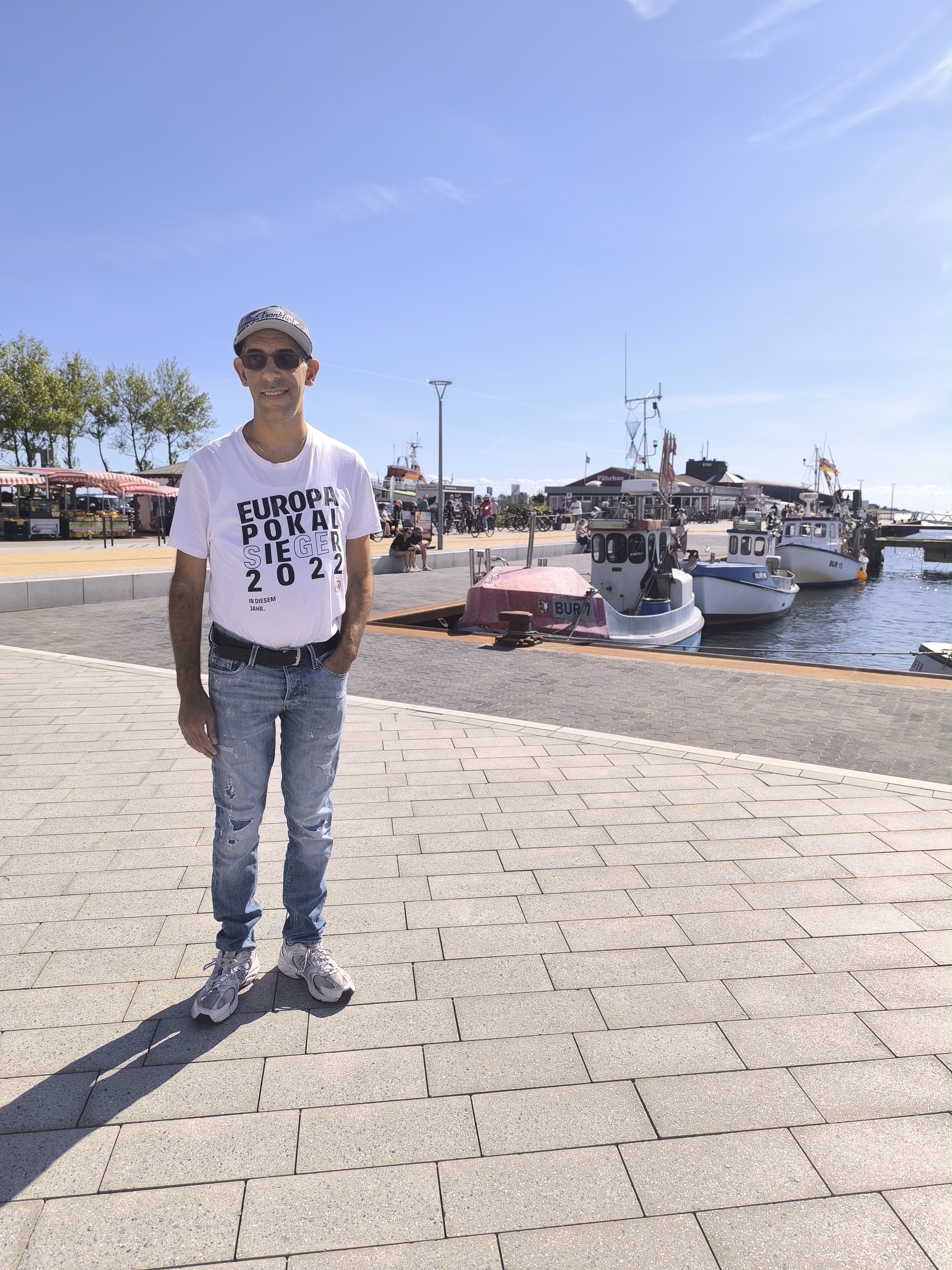 Ein Urlauber genießt einen sonnigen Tag am Hafen.