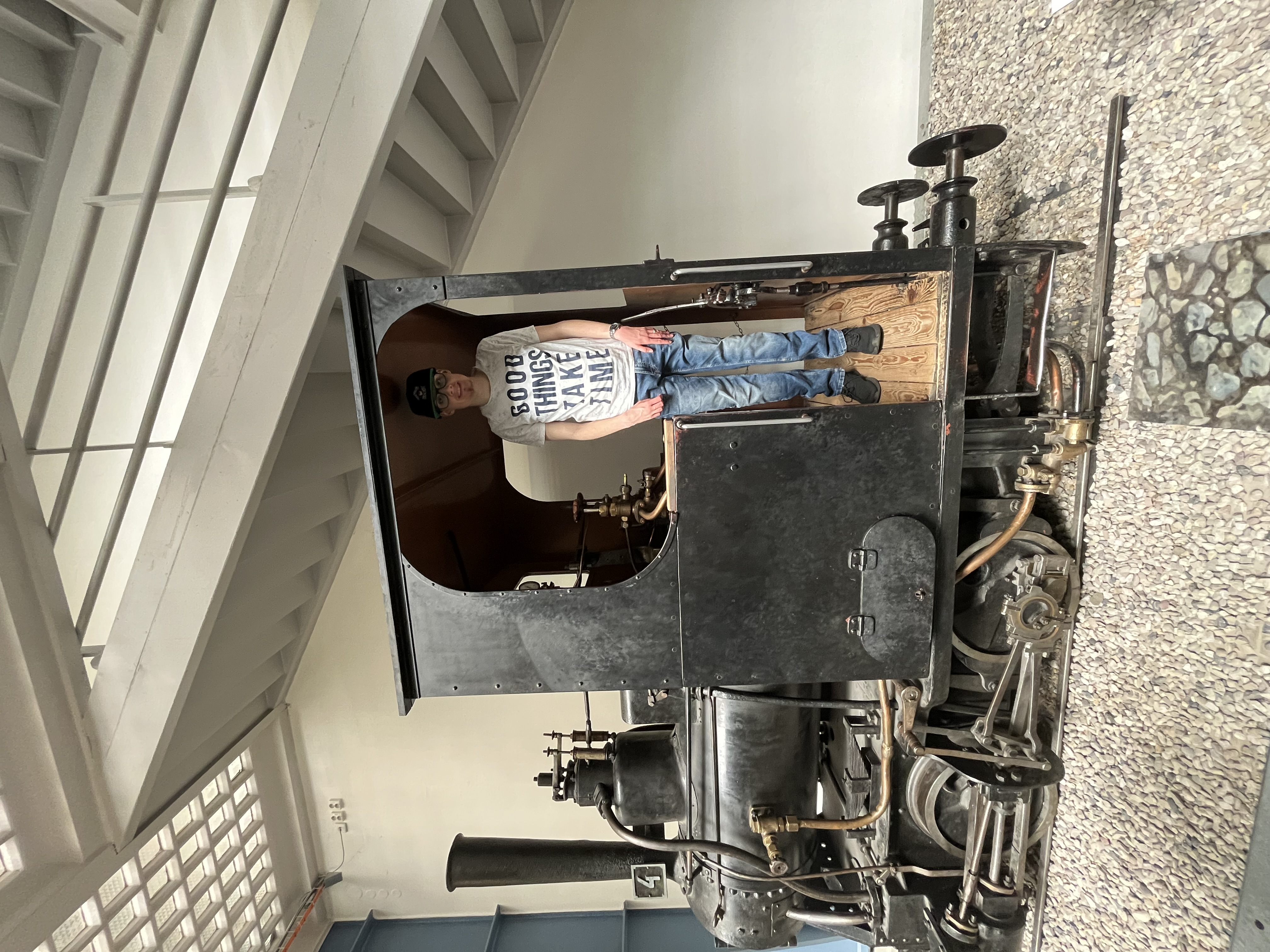 Ein Urlauber steht glücklich auf einer alten Eisenbahn.