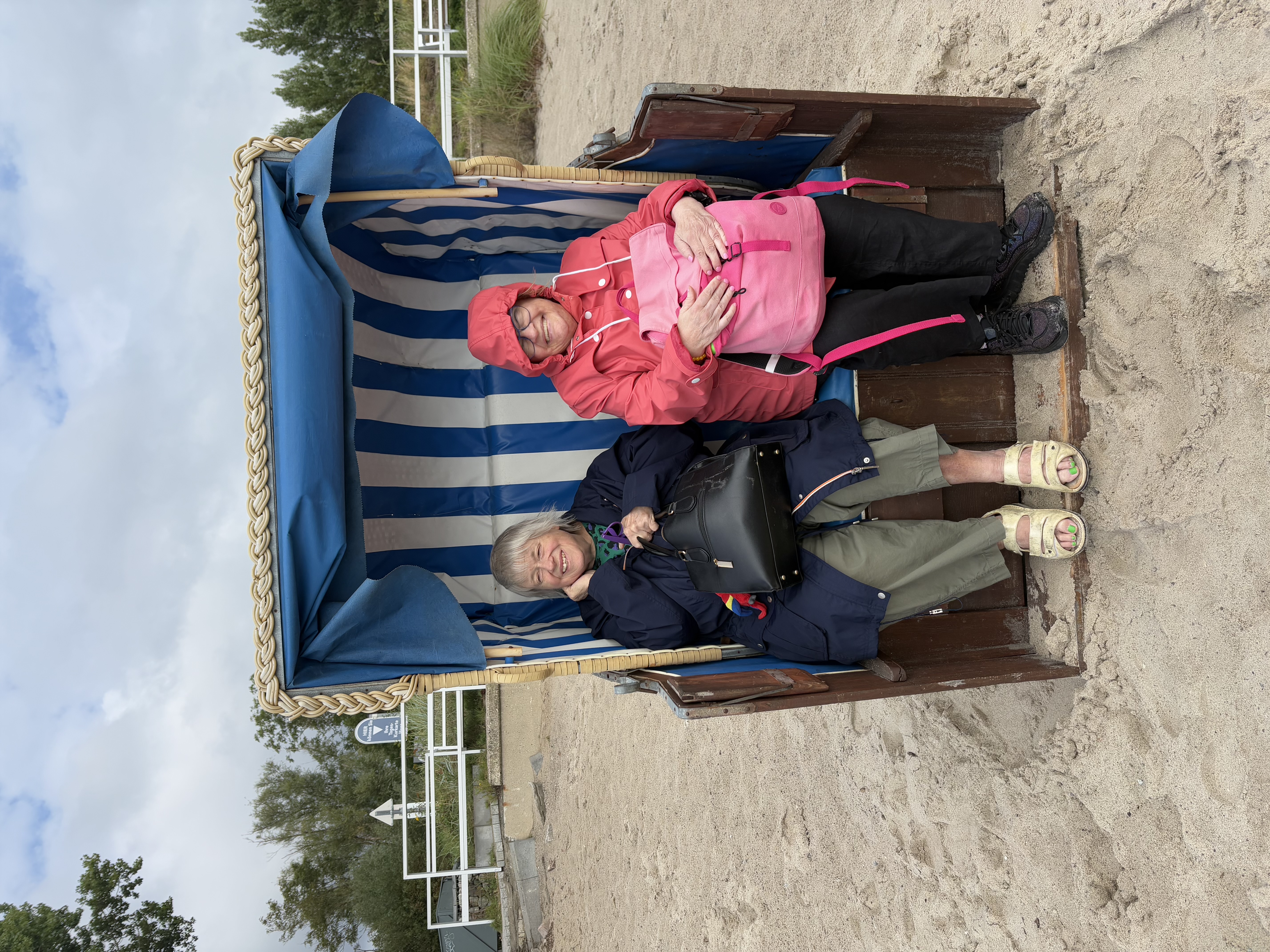 Zwei Mitreisende sitzen gemütlich im Strandkorb.