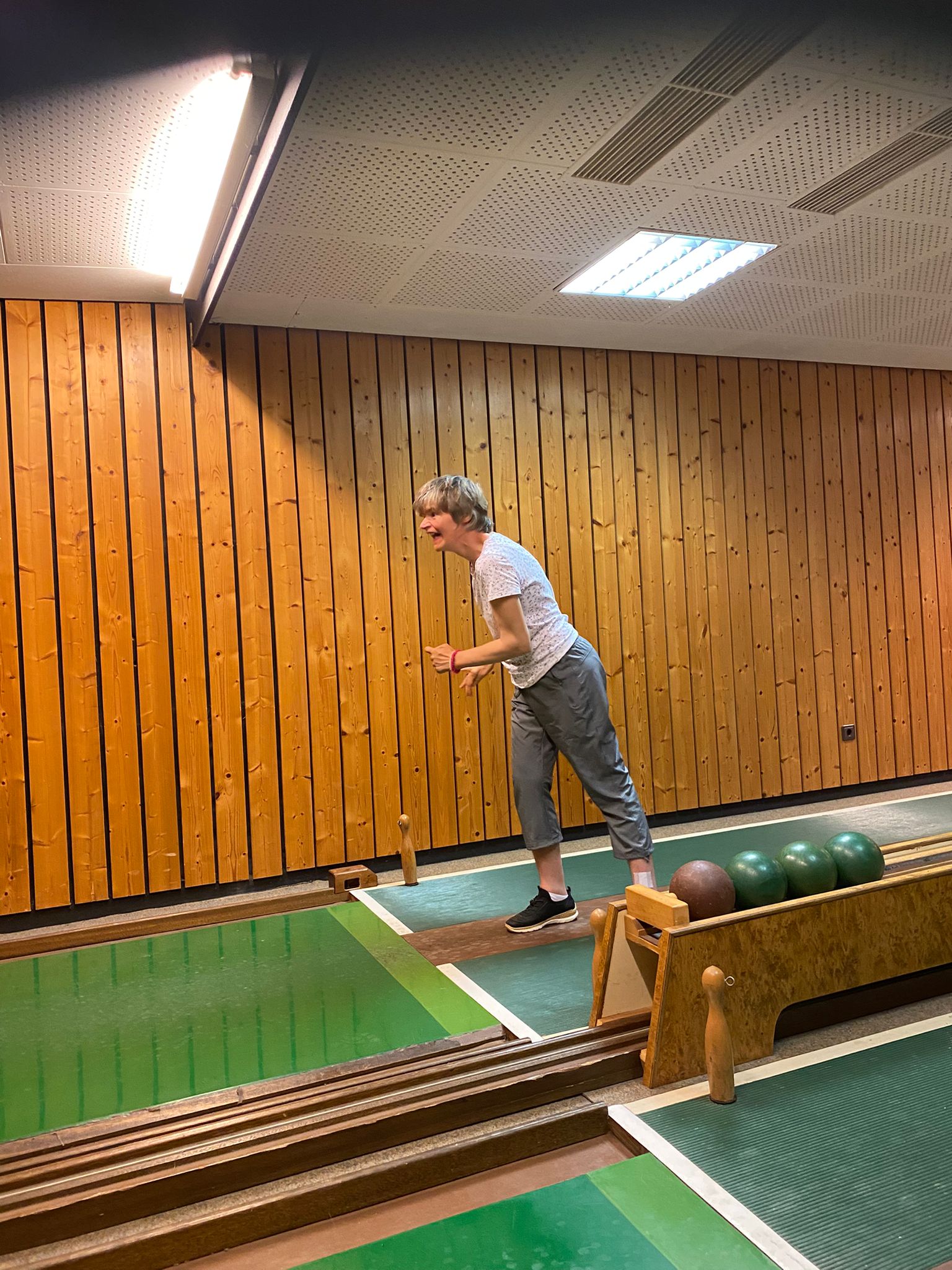 Eine Urlauberin hat Spaß beim Kegeln.